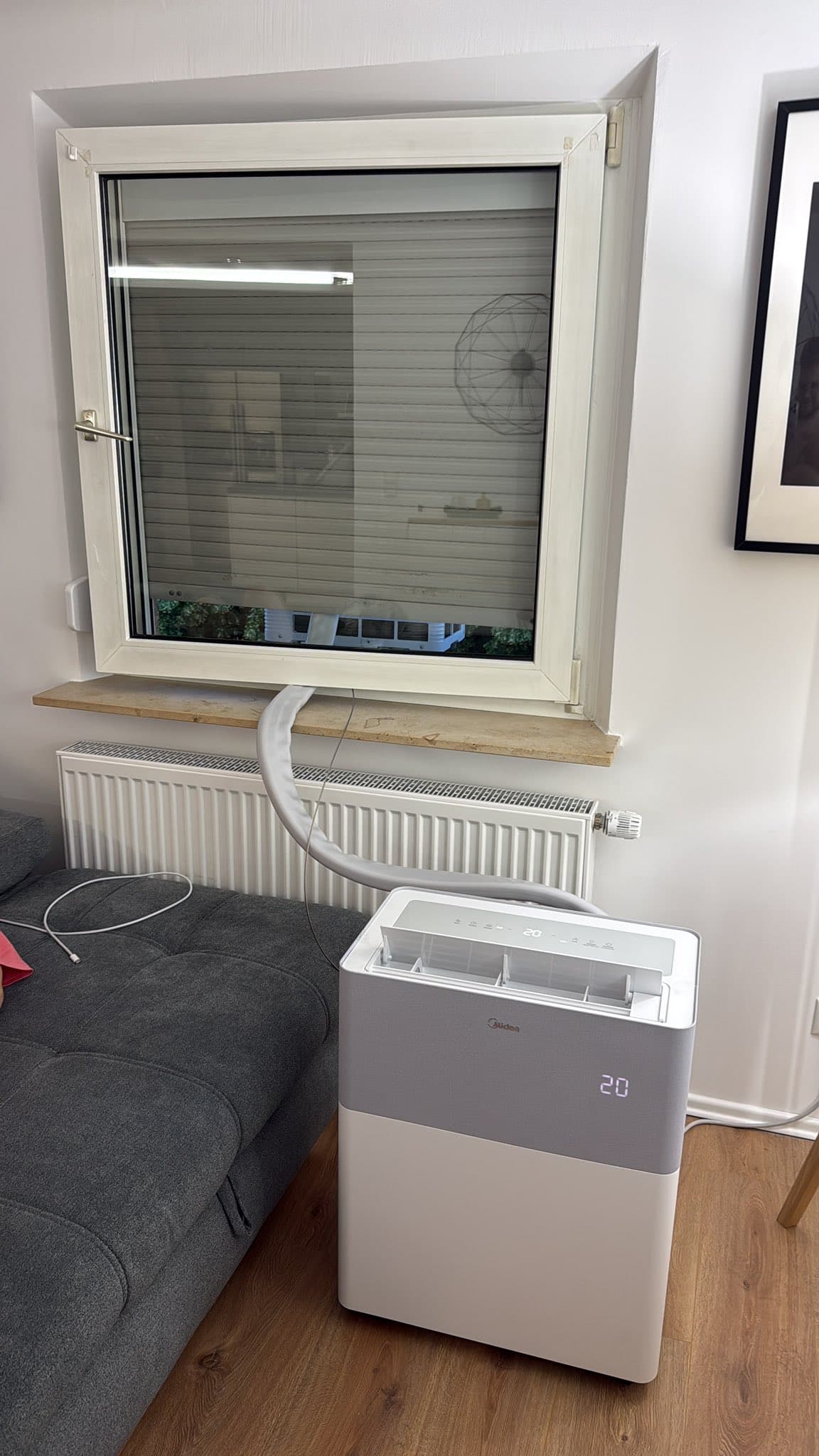 Midea PortaSplit installée à côté d'un canapé, afficheur sur 20 degrés